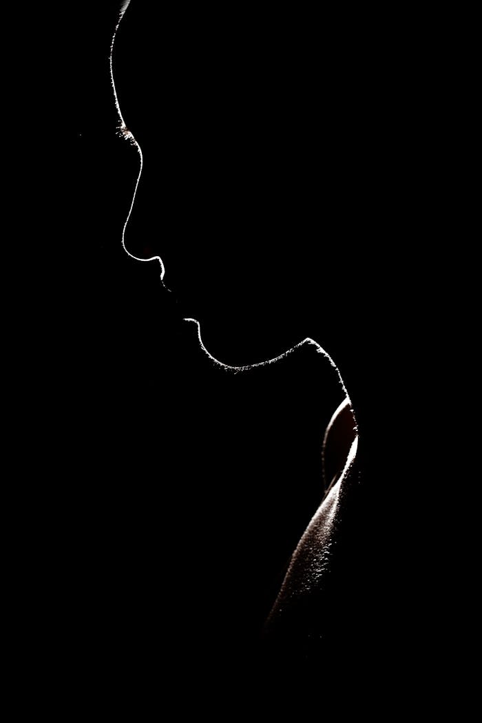 Romantik Mi, Suçlu Mu? Bonnie ve Clyde’ın Psikolojik Anatomisi Artistic silhouette of a person against a dark background, evoking mystery and solitude.