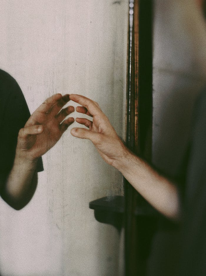 The Art of Drawing Readers In: Your attractive post title goes here A person's hand reaching towards its reflection in a mirror, creating a mysterious mood.